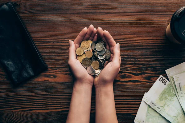 Manos con monedas y billetes - foto de stock