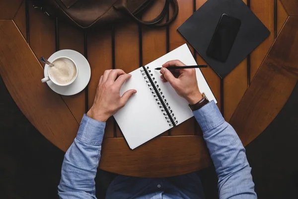 Hombre escribiendo en Bloc de notas - foto de stock