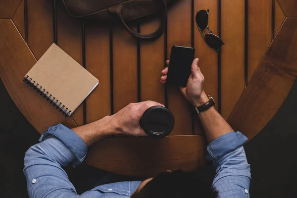 Hombre con café para ir con teléfono inteligente - foto de stock