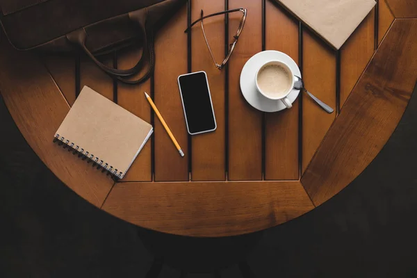 Smartphone, notepad and cup of coffee — Stock Photo