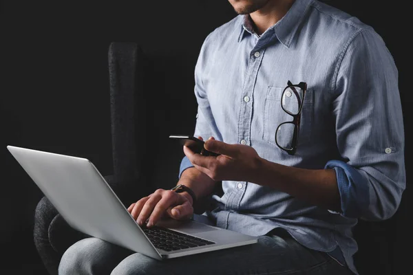 Man using smartphone and laptop — Stock Photo