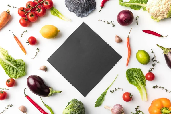 Black board among uncooked vegetables — Stock Photo