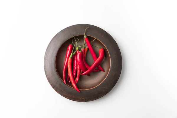 Red chili peppers on black plate — Stock Photo