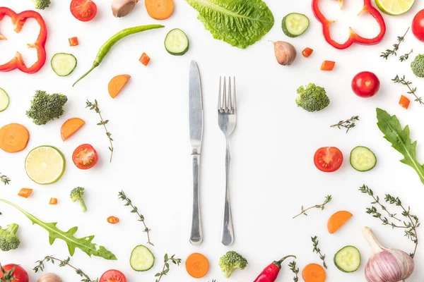 Cuchillo y tenedor en círculo de verduras cortadas - foto de stock