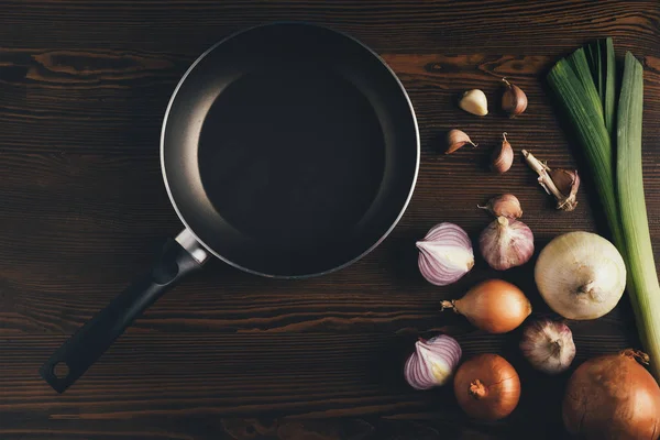 Sartén vacía y cebolla con ajo - foto de stock