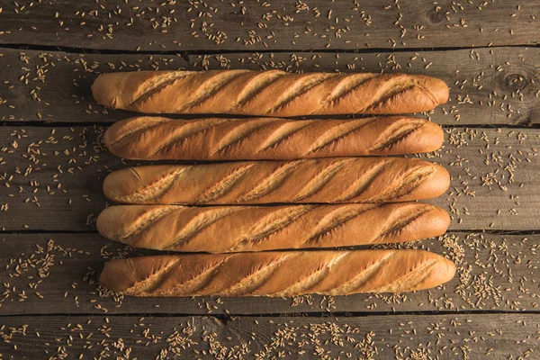 Baguette e grani sul tavolo — Foto stock