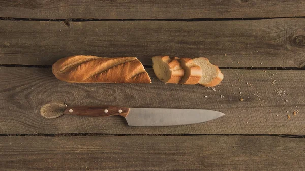 Baguette en rodajas y cuchillo - foto de stock