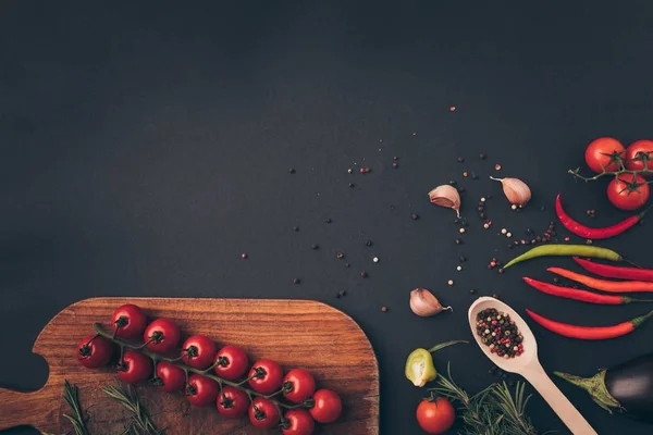 Ansicht von Kirschtomaten und Gewürzen auf grauem Tisch — Stockfoto