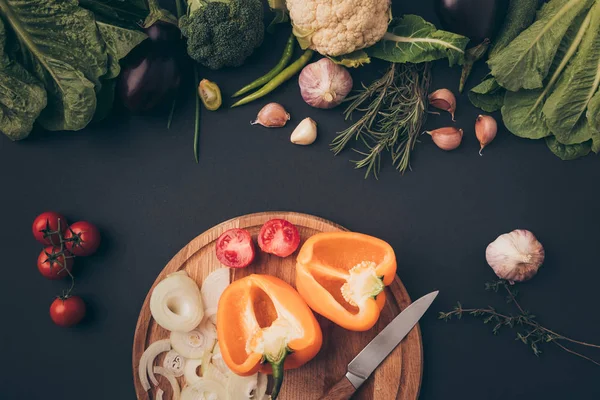Вид сверху на зеленые овощи и перец на деревянной доске на сером — стоковое фото
