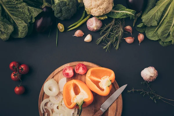 Vue du dessus des légumes verts et poivron sur planche de bois sur gris — Photo de stock