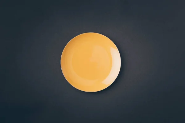 Vue de dessus de la plaque jaune sur la table grise — Photo de stock
