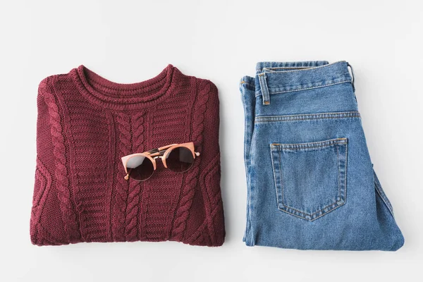 Trendy knitted sweater and jeans and sunglasses — Stock Photo