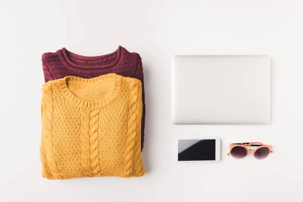 Suéteres, laptop y smartphone - foto de stock
