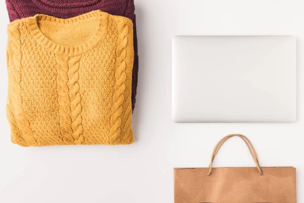 Sweaters, laptop and shopping bag — Stock Photo