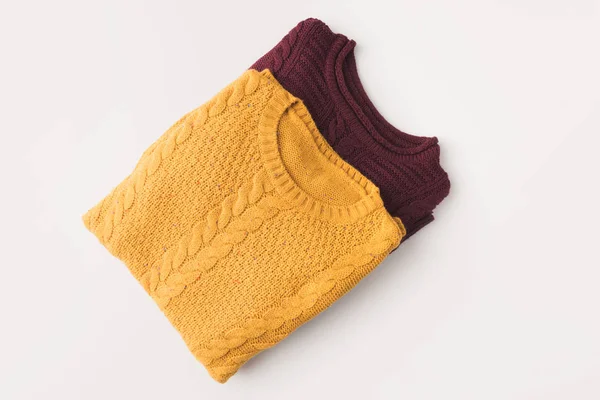 Knitted burgundy and yellow sweaters — Stock Photo