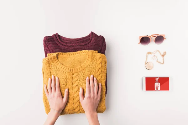 Sweaters and smartphone with youtube appliance — Stock Photo