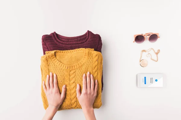 Sweaters and smartphone with facebook messenger — Stock Photo