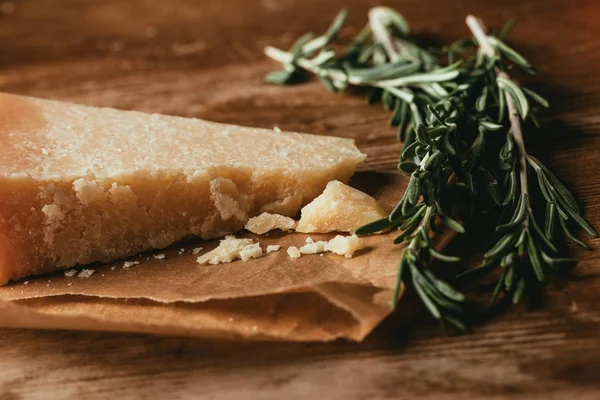 Primo piano di parmigiano e rosmarino fresco su un tavolo di legno — Foto stock