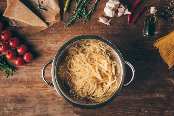 Vue du dessus des pâtes spaghetti et des ingrédients sur la table en bois — Photo de stock