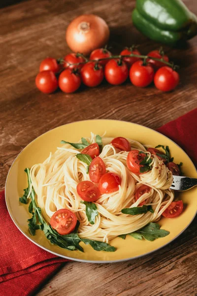 Deliciosa massa italiana com tomate e rúcula em prato — Fotografia de Stock