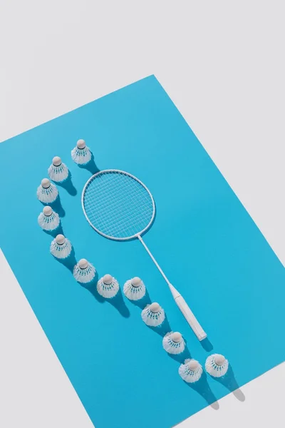 Visão de alto ângulo de raquete de badminton e shuttlecocks em papel azul, isolado em branco — Fotografia de Stock