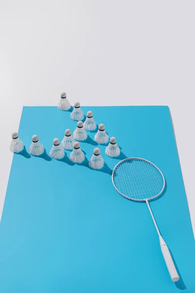 Komposition mit weißem Badmintonschläger und Federbällen auf blauem Papier — Stockfoto