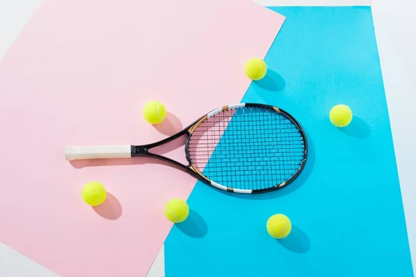 Vista superior de raquete de tênis e bolas em papéis azuis e rosa — Fotografia de Stock