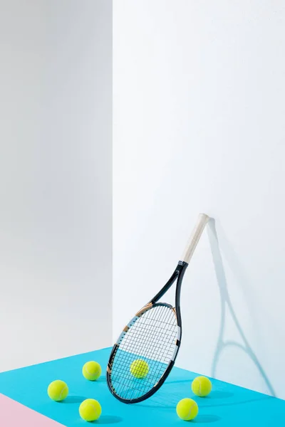 Cercle de balles de tennis sur bleu autour de raquette de tennis au mur blanc avec espace de copie — Photo de stock