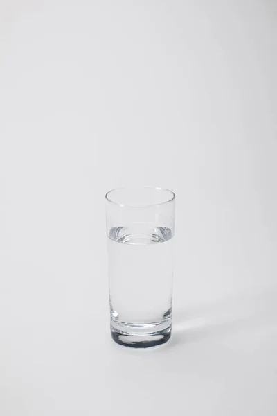 Transparent glass with calm water on white — Stock Photo