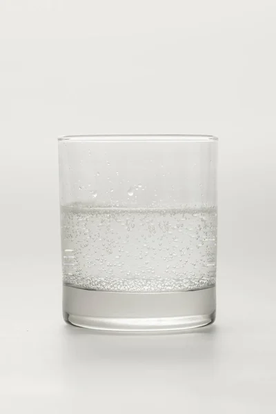 Verre avec eau minérale scintillante isolé sur blanc — Photo de stock