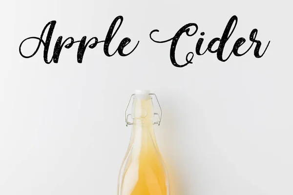 Bouteille de cidre de pomme avec inscription manuscrite sur une surface blanche — Photo de stock