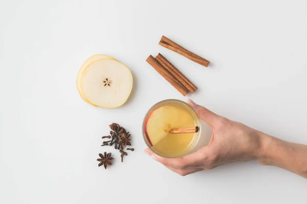 Cropped shot of woman holding glass of apple cider on white surface — Stock Photo