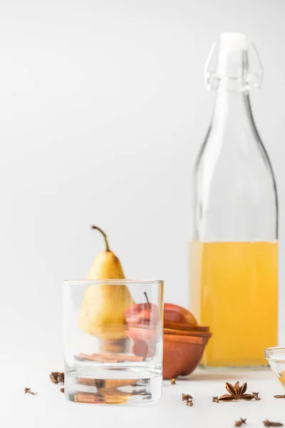 Köstlicher Apfelwein in Flasche mit Glas und Früchten auf weißer Oberfläche — Stockfoto