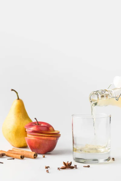 Close-up shot of cider pouring in glass on white table — Stock Photo