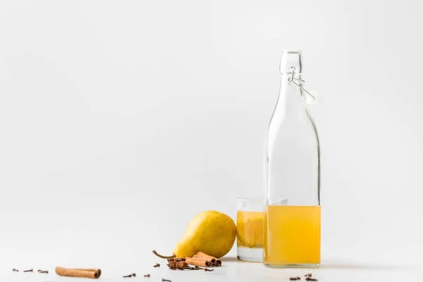 Bouteille de délicieux cidre de poire aux épices sur table blanche — Photo de stock