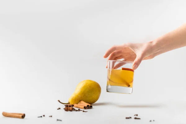 Tiro recortado de mujer sosteniendo vaso de sidra de pera con especias - foto de stock