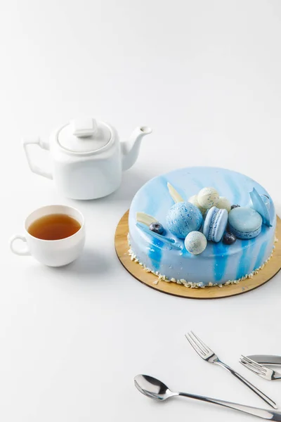 Синій смачний торт на рубаній дошці з чаєм ізольований на білому — стокове фото