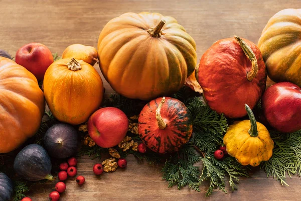 Various fruits and vegetables with fir branches on wooden table — Stock Photo