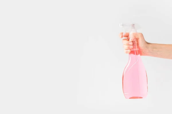 Vista recortada de la mano sosteniendo botella de spray rosa, aislado en blanco - foto de stock