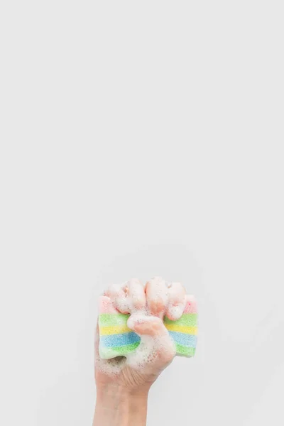Vista recortada de la mano que sostiene la esponja de lavado con espuma, aislada en blanco - foto de stock