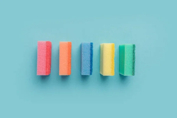 Top view of row of colorful washing sponges, on blue — Stock Photo