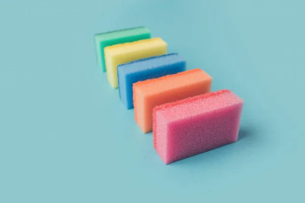 Linha de esponjas de cozinha de lavagem coloridas, em azul — Fotografia de Stock