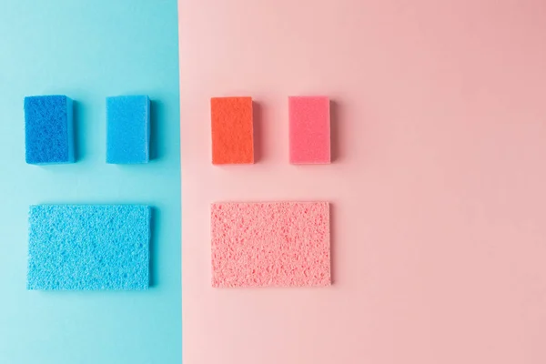 Vue de dessus des éponges de lavage colorées, sur rose et bleu — Photo de stock