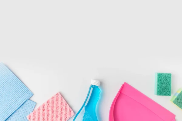 Vista superior de esponjas de lavagem coloridas, garrafa e colher, isolado em branco — Fotografia de Stock