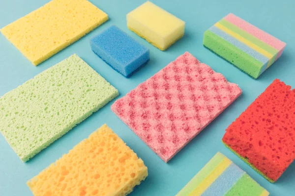 Background with different colorful washing kitchen sponges, on blue — Stock Photo