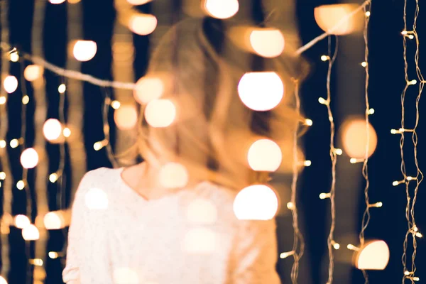 Beautiful christmas garland with blurred woman moving on background — Stock Photo