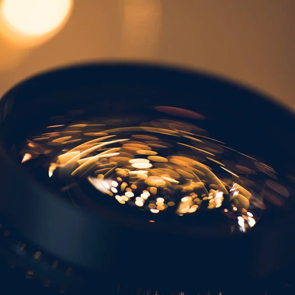 Close-up shot of holiday lights reflecting in glass of camera lens — Stock Photo