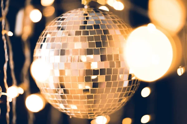 Golden glossy disco ball with christmas lights around — Stock Photo