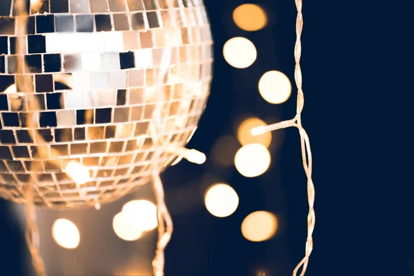 Close-up shot of disco ball with garland on black background — Stock Photo