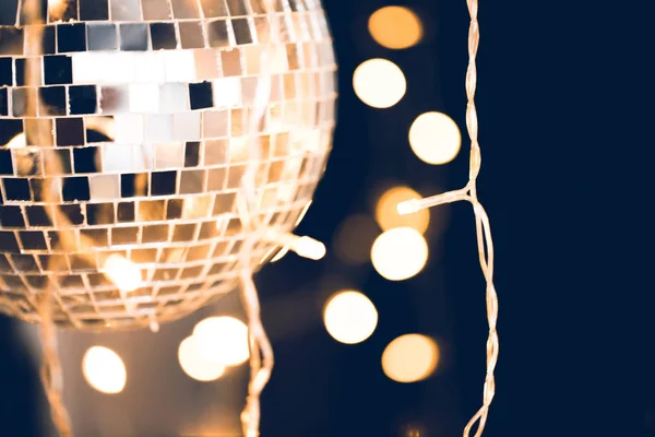 Close-up shot of disco ball with garland on black background — Stock Photo